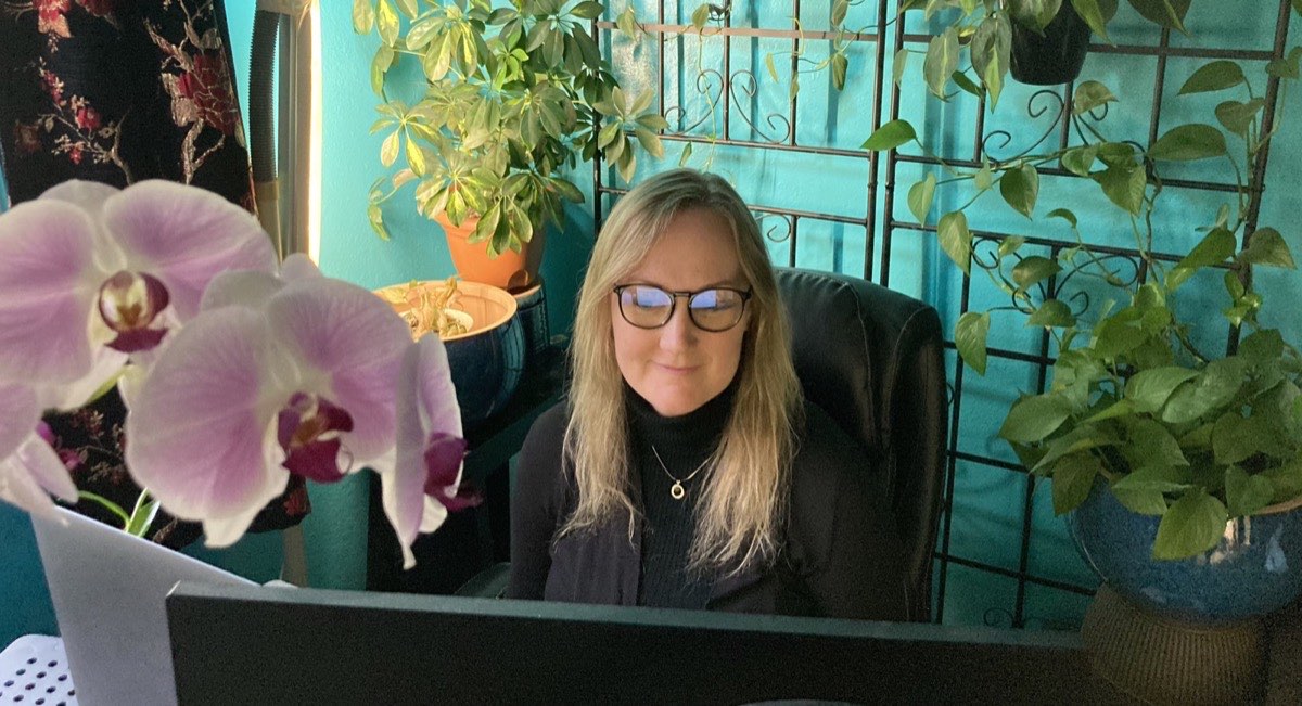 Julie Hurley working at her desk surrounded by plants